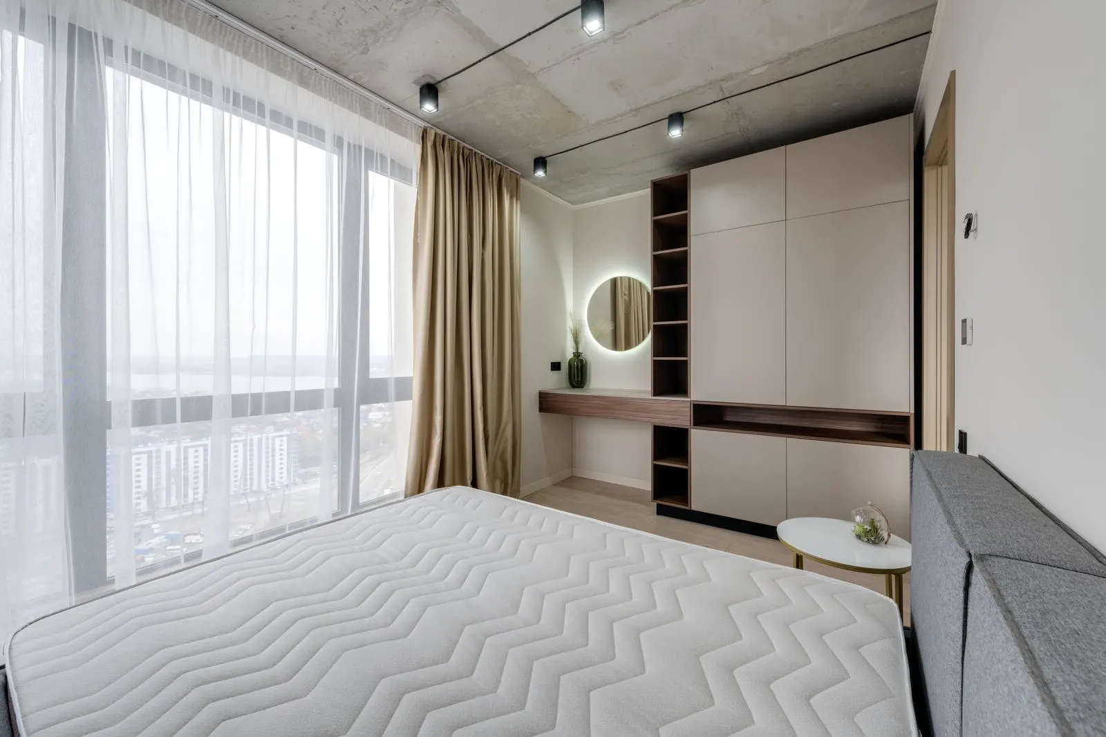 Bright bedroom with a neatly made white bed.